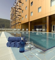 Una piscina al aire libre de temporada, sillones reclinables de piscina