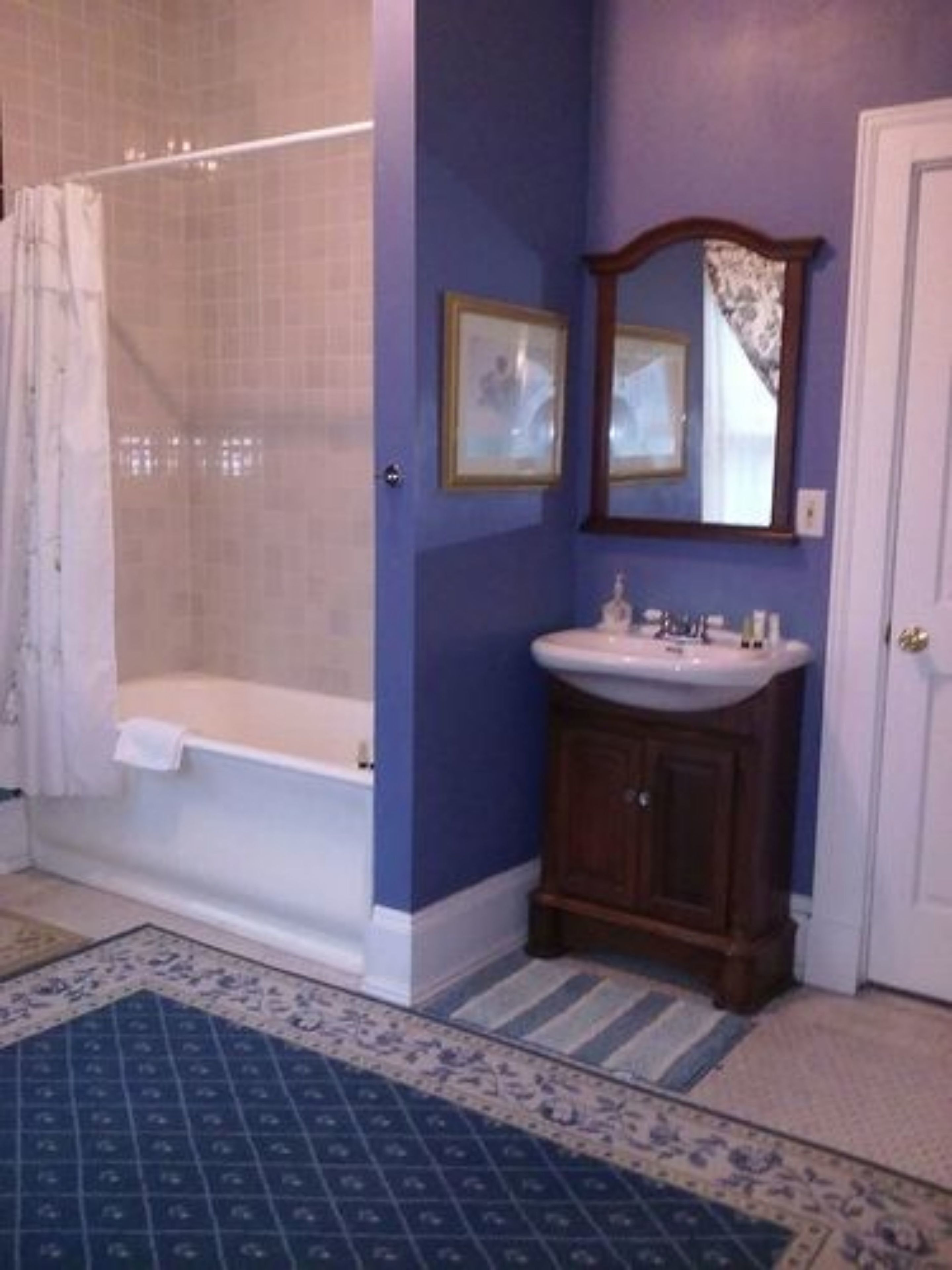 Une salle de bain avec une baignoire, un lavabo et un miroir.