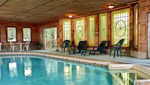 Un área de piscina con maderería, sillas y una mesa.