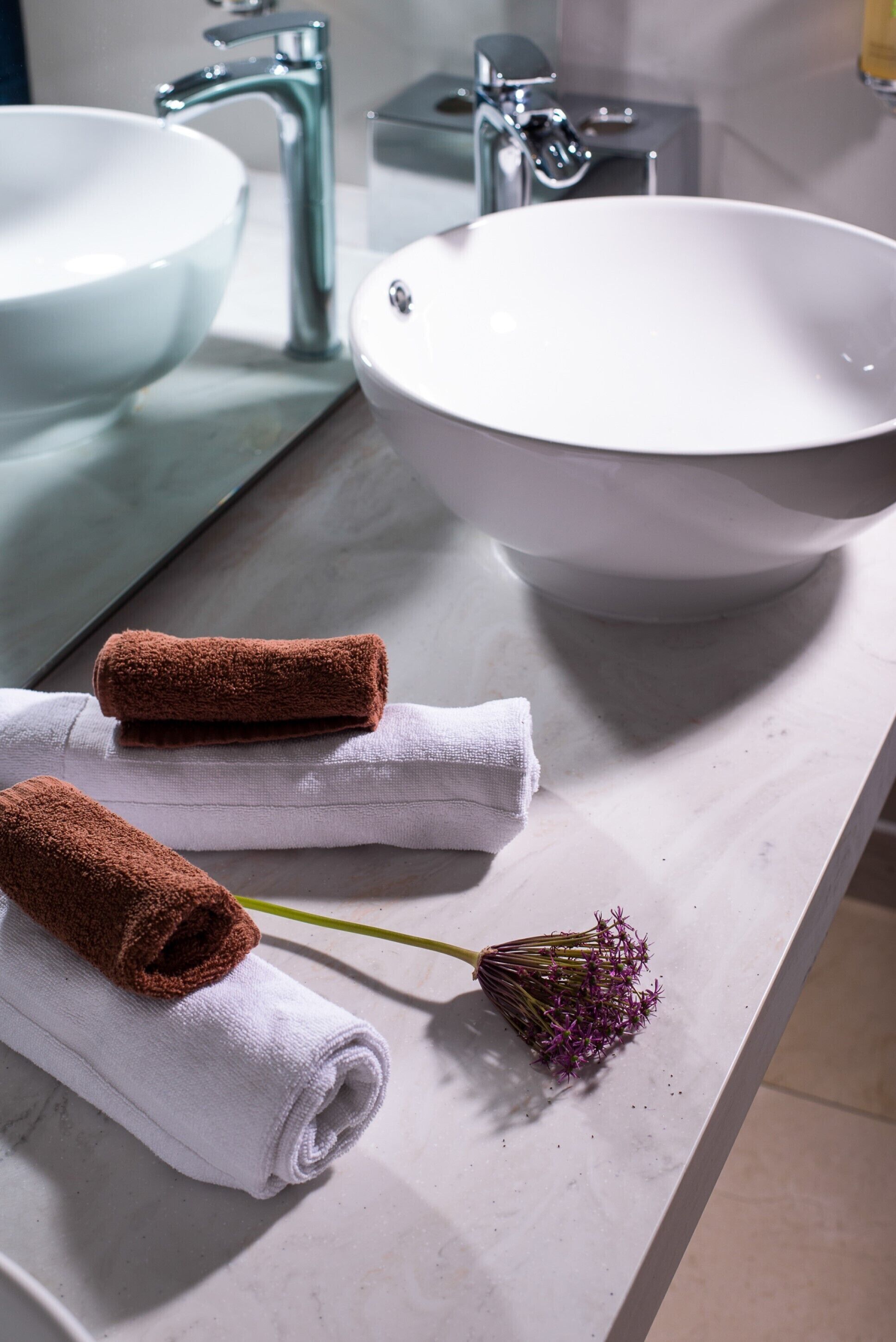 Une salle de bain avec deux lavabos, un miroir et des serviettes.