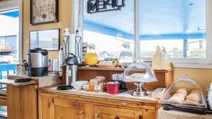 A wooden counter with a coffee maker, a kettle, and a glass pitcher. - Rodeway Inn & Suites (Long Beach)