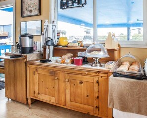 A wooden counter with a coffee maker, a kettle, and a glass pitcher. - Rodeway Inn & Suites (Long Beach)
