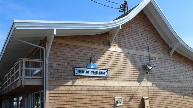A building with a sign reading 'INN AT THE SEA' and a balcony. - Rodeway Inn & Suites (Long Beach)