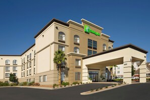 A Holiday Inn Express hotel with a modern design, featuring a prominent entrance and a parking lot. - Holiday Inn El Paso Airport by IHG (El Paso)