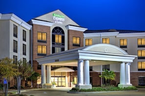 Edificio de Holiday Inn Express & Suites con entrada cubierta y varias ventanas.