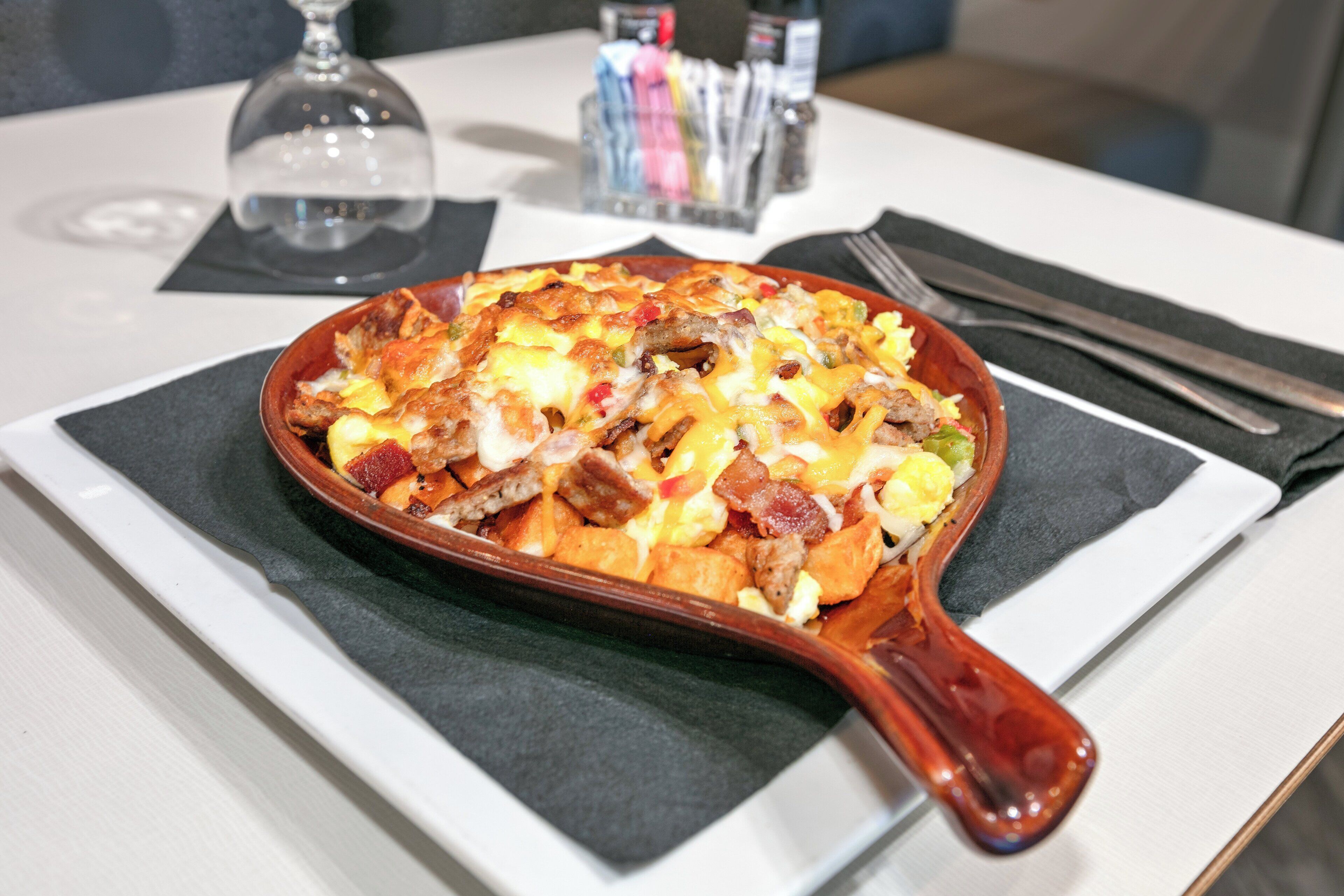 A breakfast dish in a skillet on a table.