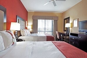 A hotel room with two beds, a desk, a chair, a television, and a ceiling fan. - Holiday Inn Houma by IHG (Houma)