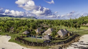 A resort with thatched-roof huts, a pool, and a beach. - Shanti Maurice Resort & Spa (Chemin Grenier)