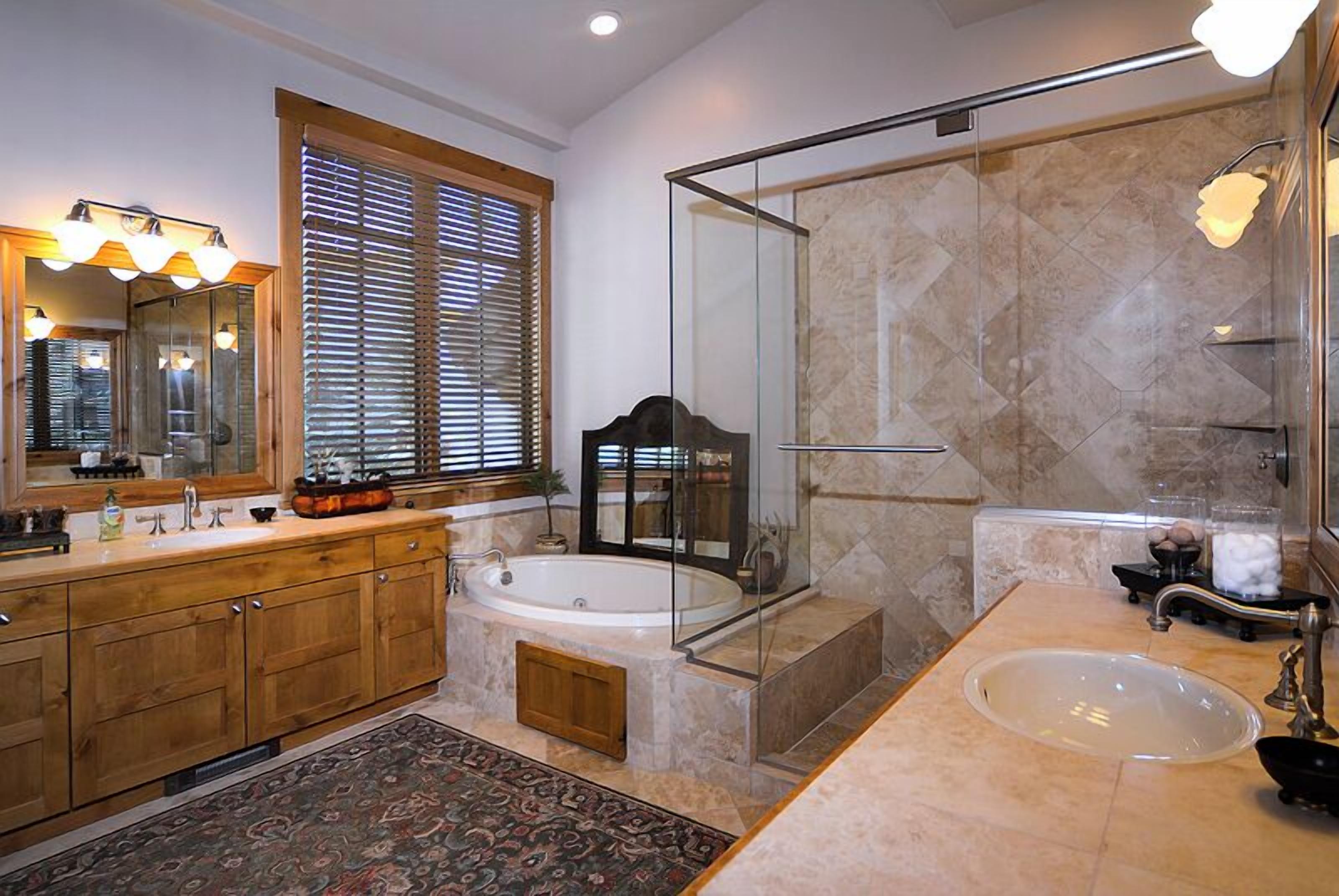 A modern bathroom with a large vanity, a freestanding bathtub, a glass-enclosed shower, and a separate sink.