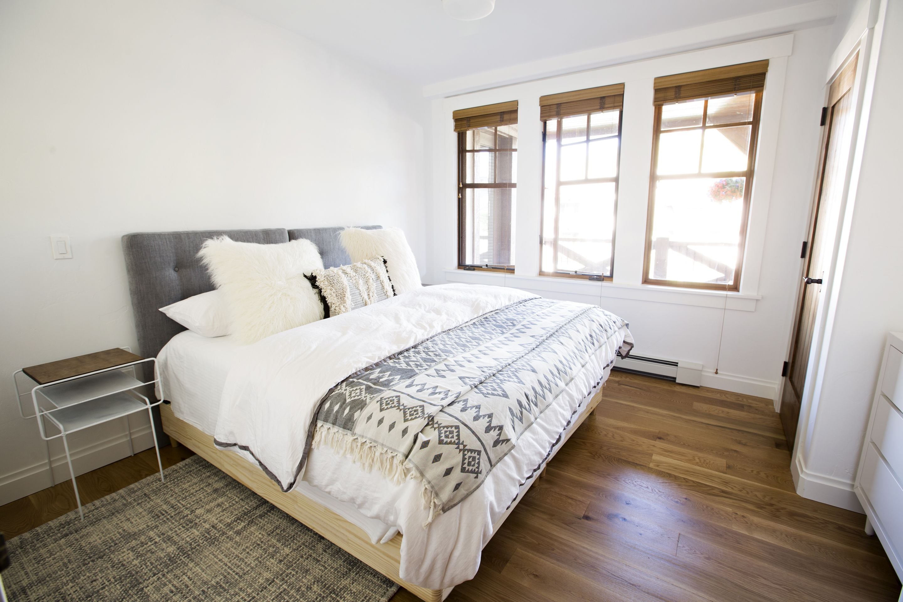 Una camera da letto con un letto, un comodino, una finestra e un termosifone.