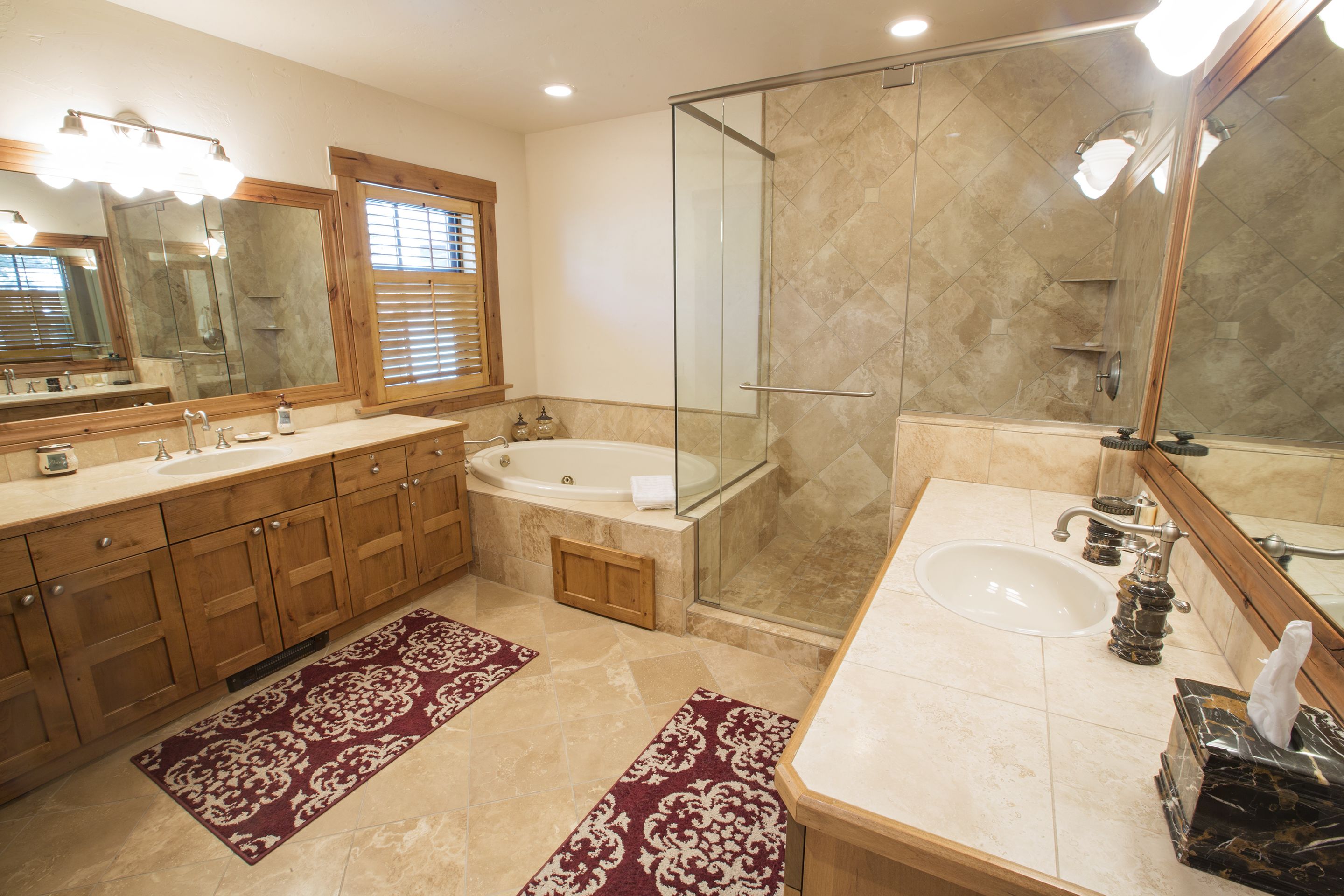 Une salle de bain avec un grand miroir, une baignoire, une douche et un lavabo.