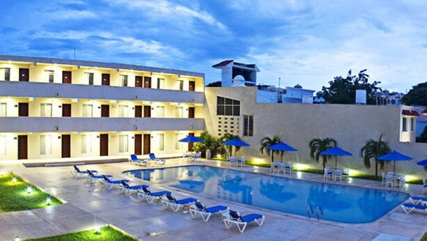 A hotel with a swimming pool, lounge chairs, and umbrellas. - Hotel Bonampak (Cancun)