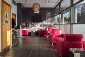 Relax in our stylish lobby with a comfortable seating area, coffee machine, and city views.