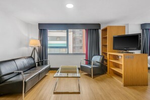 Relax in a stylish room with a leather sofa, flat-screen TV, and comfortable chair.