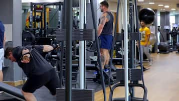 Une salle de sport équipée de divers appareils d’exercice, notamment des appareils de musculation et des tapis de course.