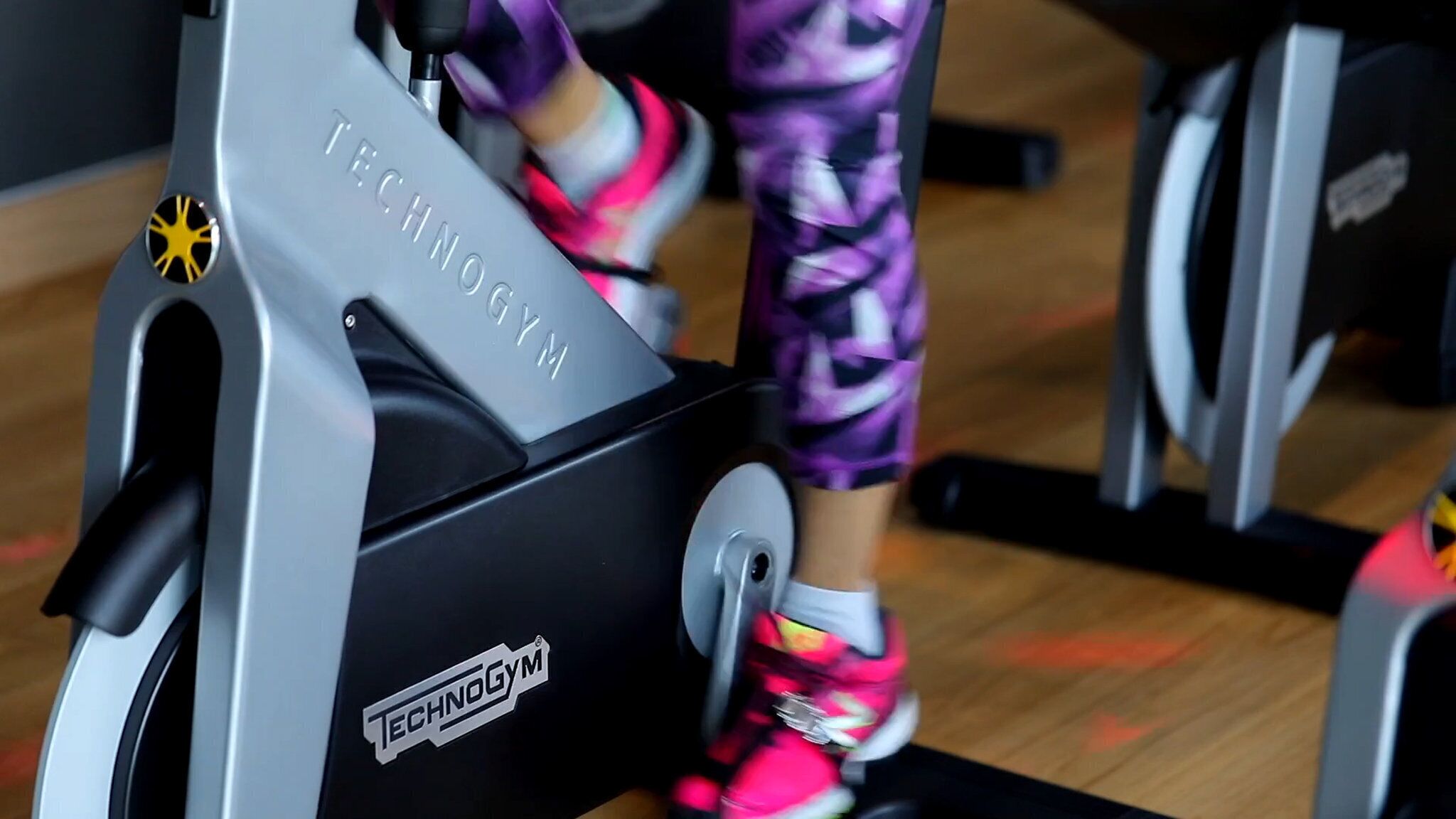 Una bicicleta estática con el nombre de marca "TECHNOGYM" a la vista en el frente.