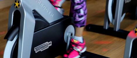 Una bicicleta estática con el nombre de marca "TECHNOGYM" a la vista en el frente.