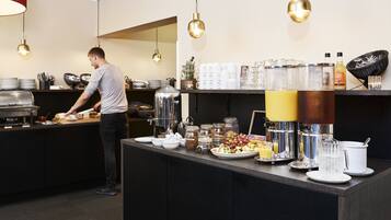 Una mesa de buffet con distintos alimentos y bebidas.