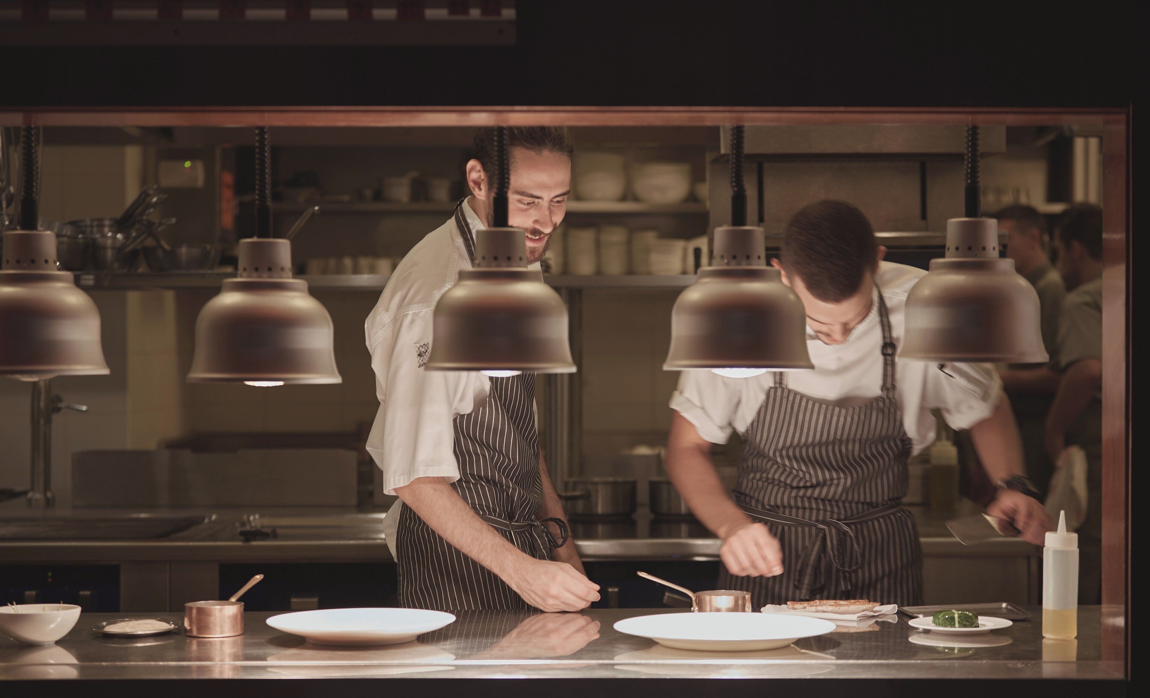 A professional kitchen with chefs preparing food.