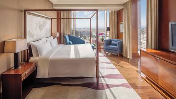 Une chambre d’hôtel moderne équipée d’un grand lit, d’un bureau, d’une chaise et d’un téléviseur.