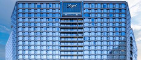 Un moderno edificio de gran altura con una fachada de ventanas en forma de cuadrícula y un llamativo letrero de 'Regent' en la parte superior.