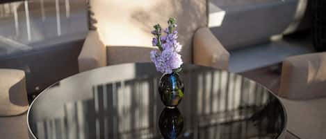 A round glass table with a vase of flowers.
