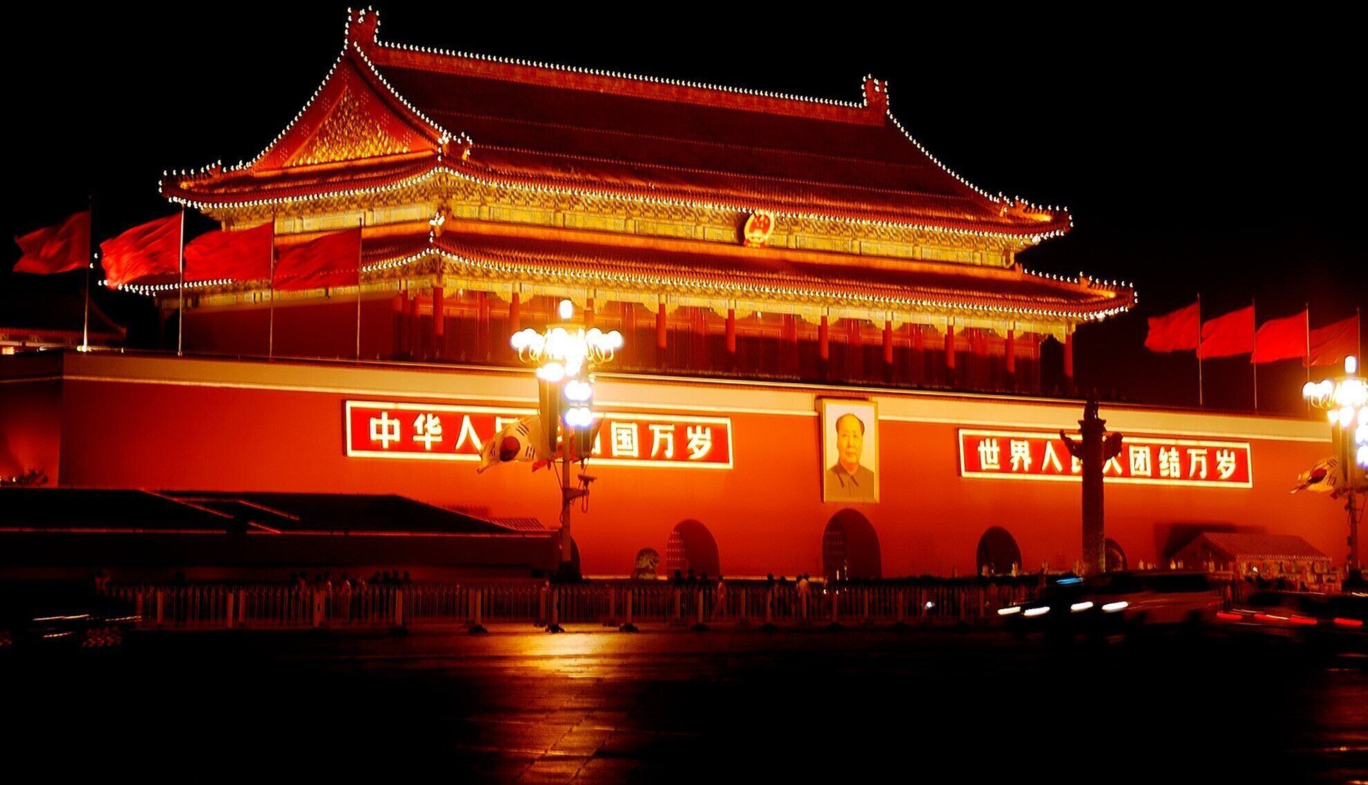Un edificio chino tradicional con señalización iluminada y banderas.