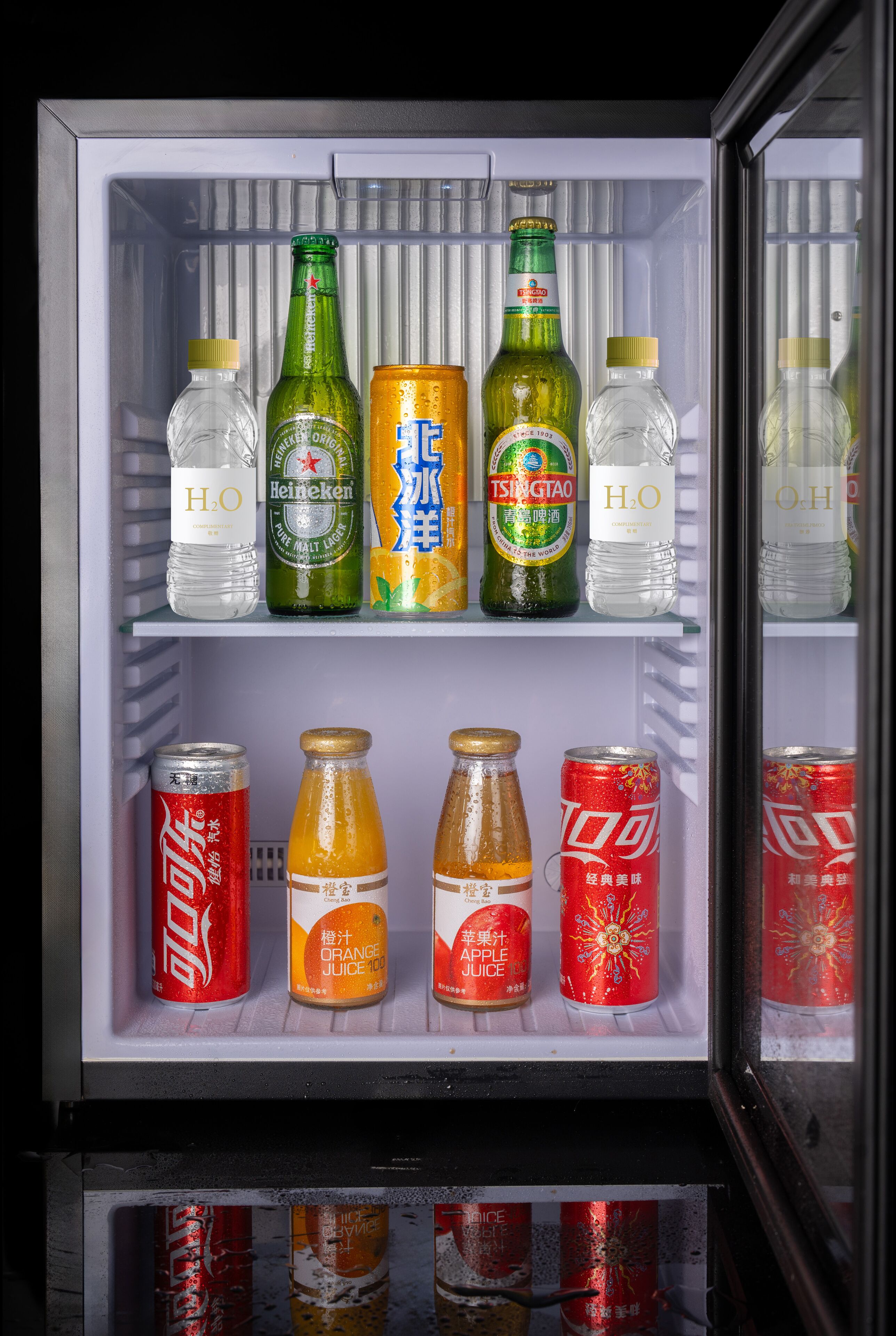 Un refrigerador lleno de diversas bebidas, incluyendo agua, cerveza y zumos de frutas.