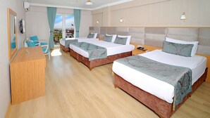Une chambre d’hôtel avec deux lits, un bureau et un balcon offrant une vue.