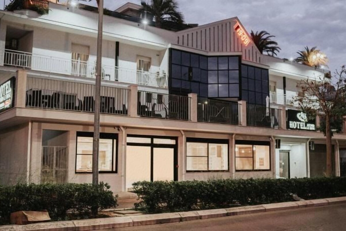 Un hôtel à l’architecture à deux étages, doté de balcons et d’une enseigne indiquant qu’il s’agit d’un hôtel.