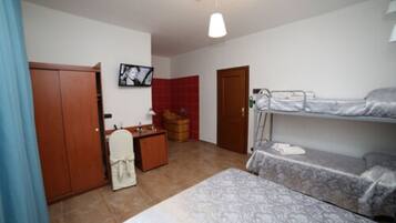 A compact room with a bed, a desk, a wardrobe, and a television.