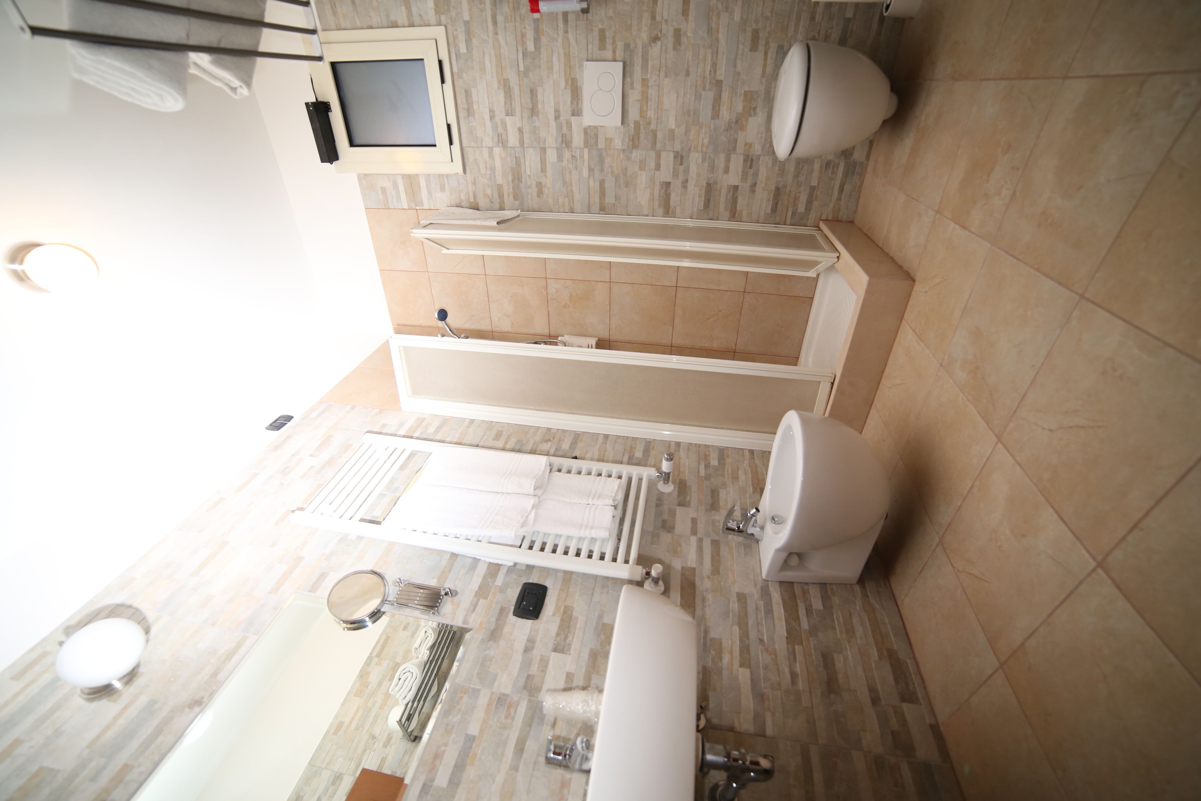 A modern bathroom with a bathtub, toilet, and sink.