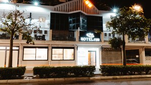 Een hotel met een modern design, herkenbaar aan een opvallend bord, grote ramen en een goed verlichte gevel.