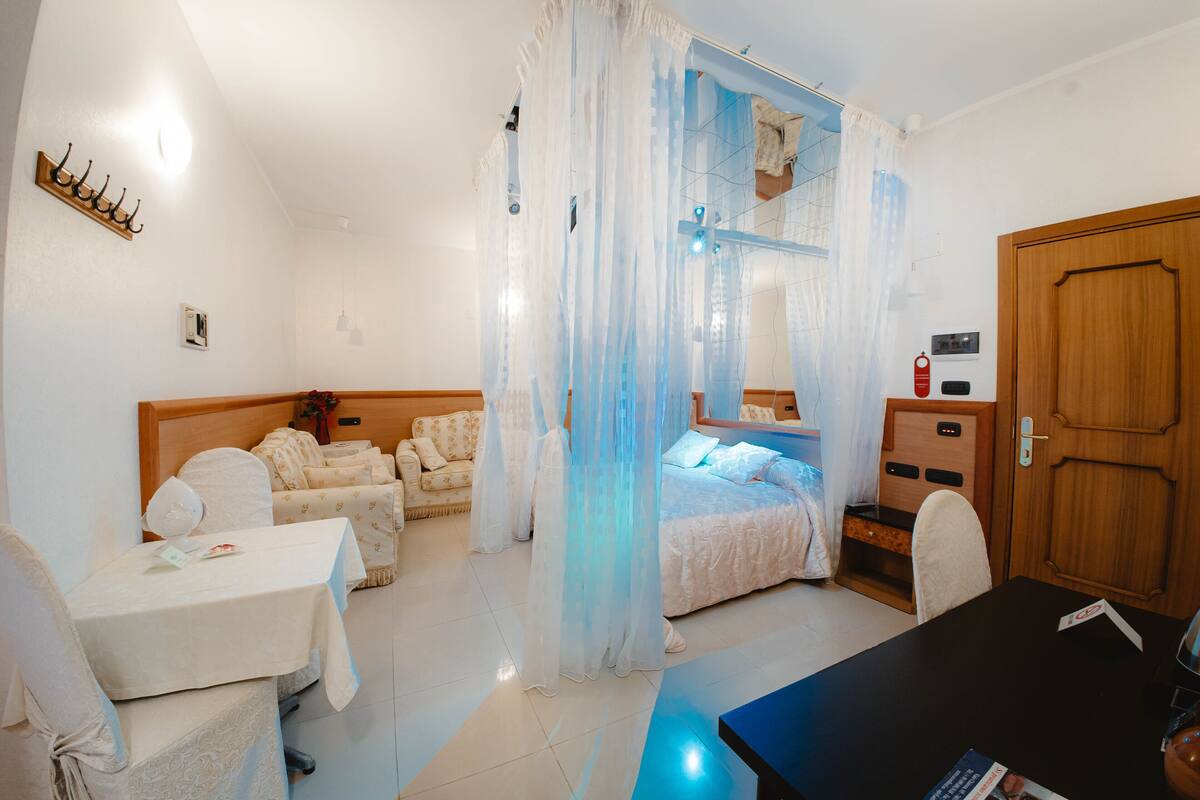 Een hotelkamer met een bed, een slaapbank, een tafel en een bureau.