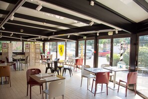 A restaurant with tables and chairs arranged for dining. - Campanile Dunkerque Sud - Loon Plage (Loon-Plage)
