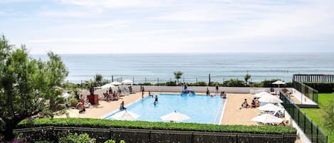 Una piscina al aire libre de temporada, sombrillas