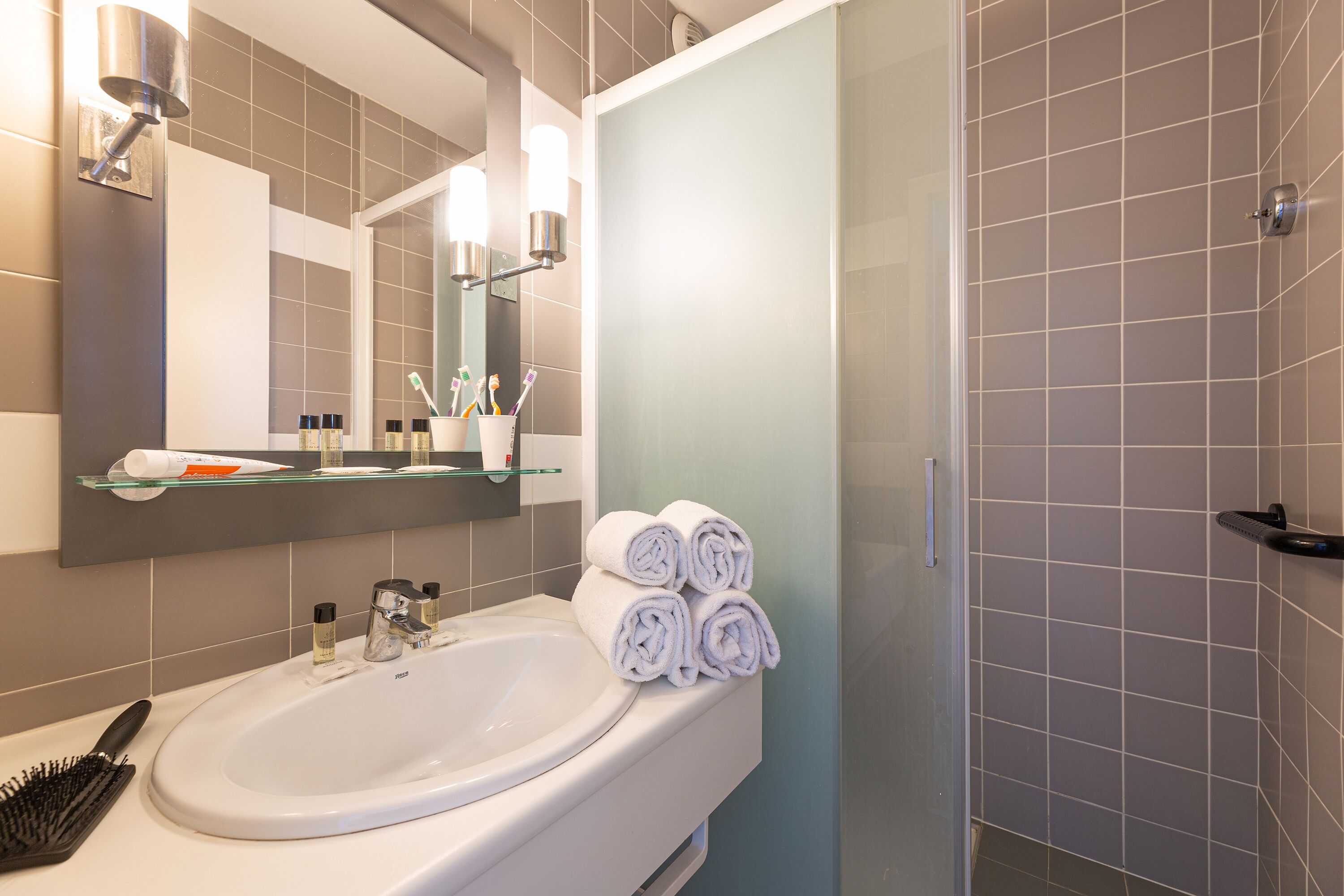 Une salle de bain avec un lavabo blanc, un miroir et un porte-serviettes.