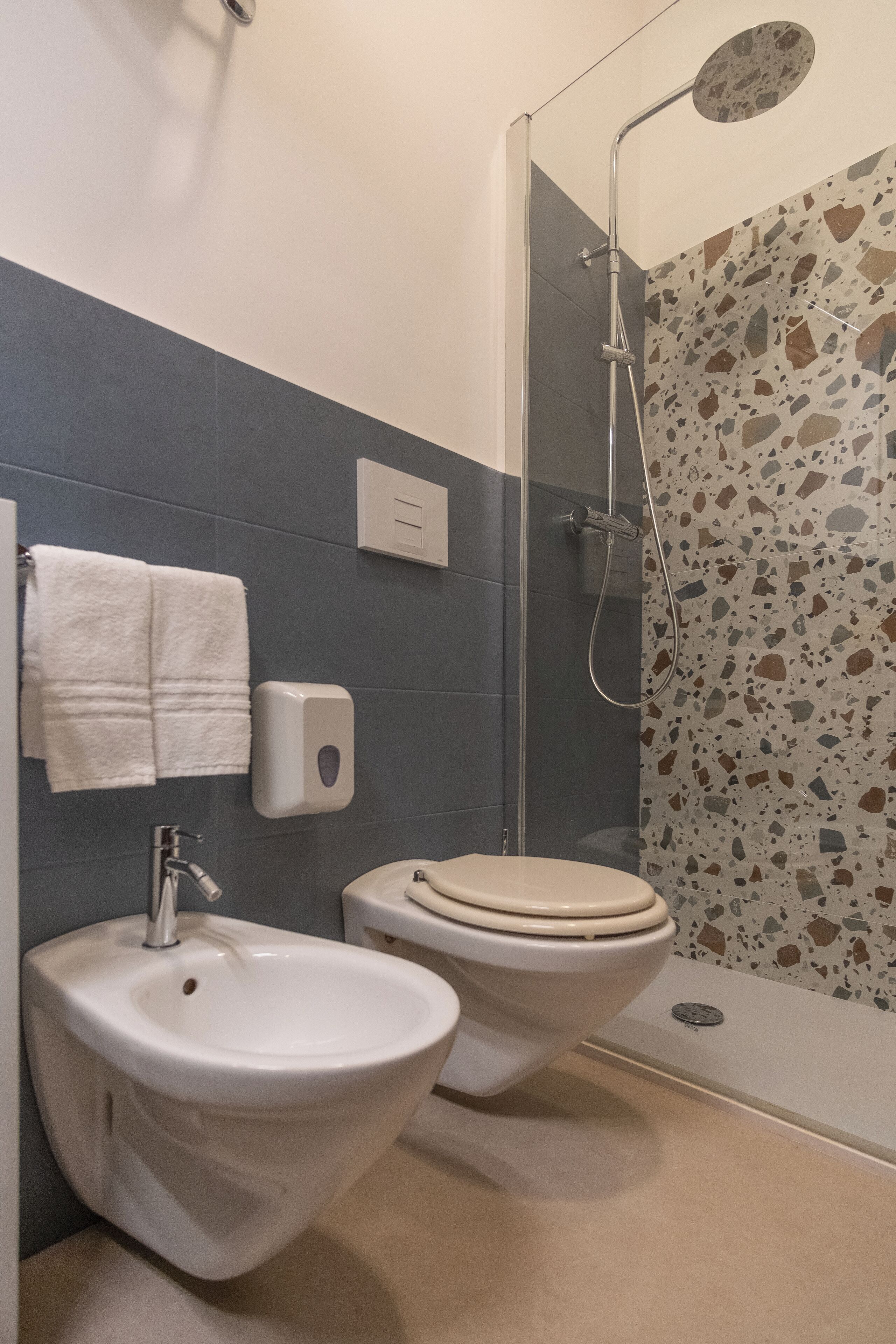 Ein Badezimmer mit einer Bidet-Einrichtung, Toilette und Dusche.