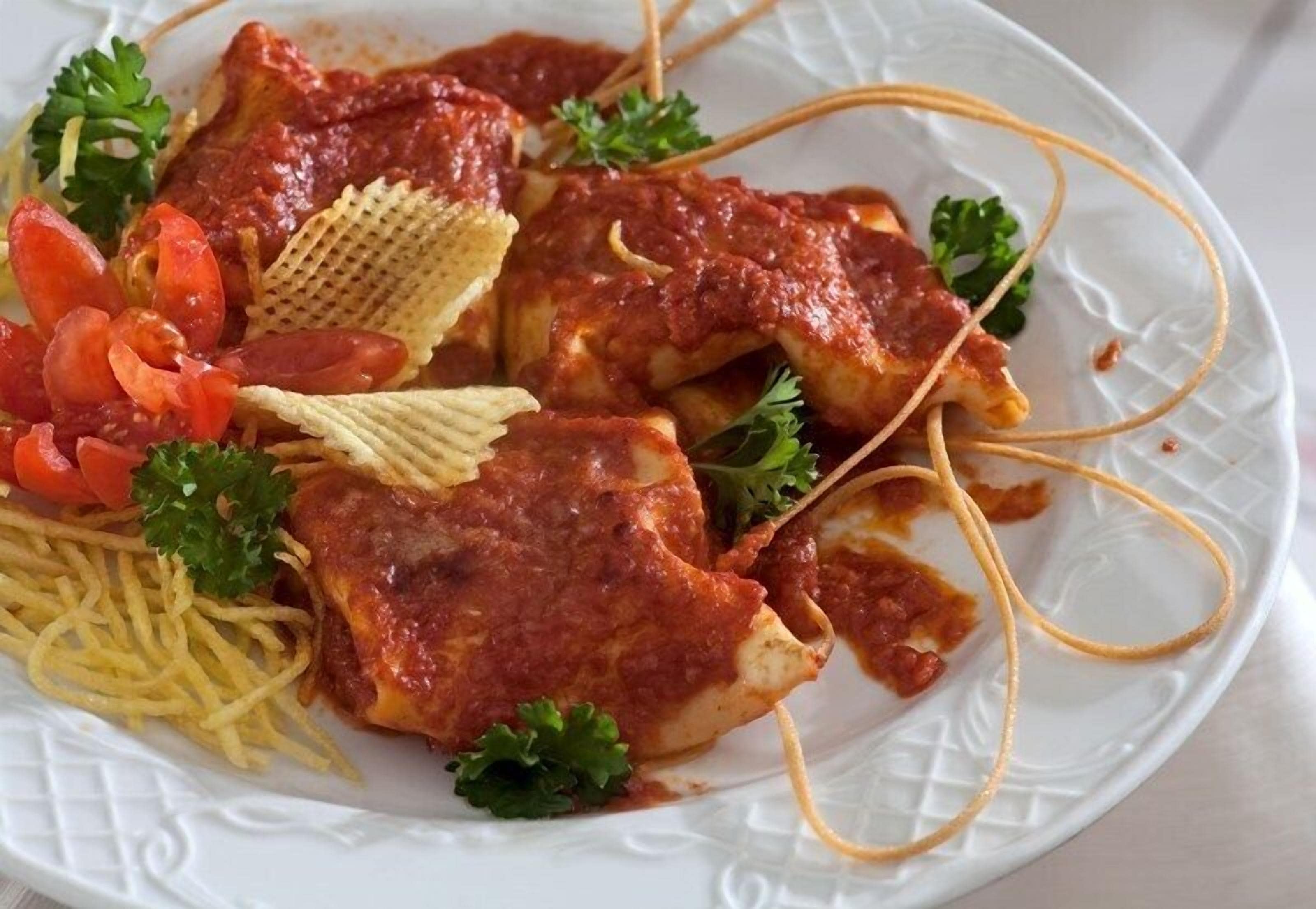 A plate of food with pasta, a piece of chicken, and some vegetables.