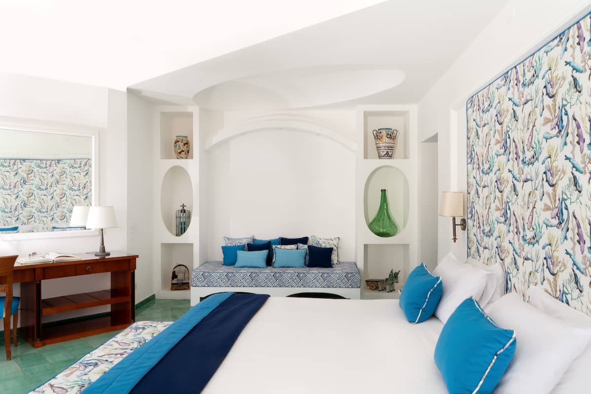 Une chambre à coucher avec un lit, des tables de chevet, un bureau et une chaise.