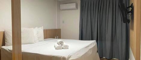 Una habitación de hotel con una cama, un escritorio y una silla.