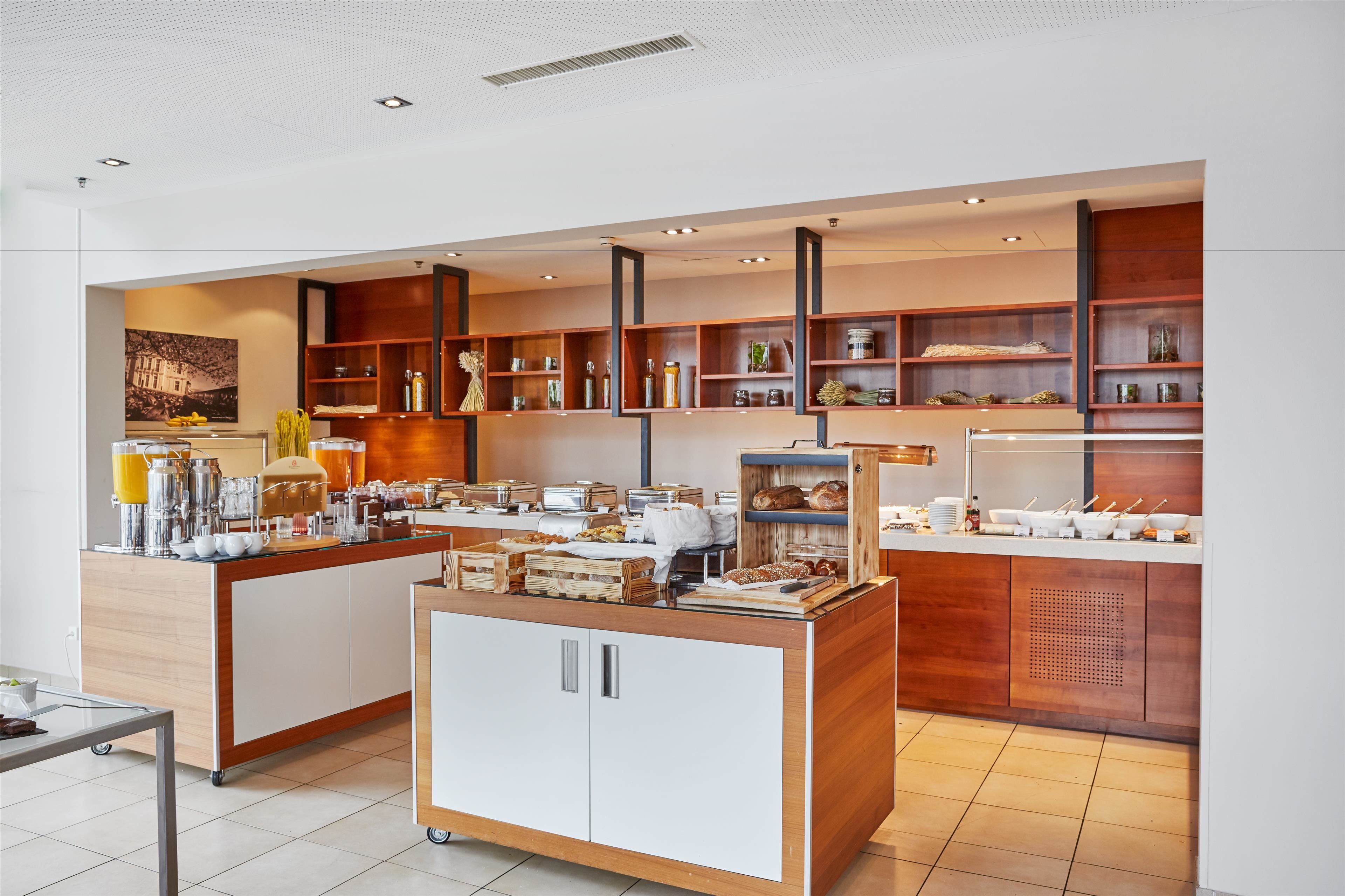 Una barra de desayuno moderna con diversos alimentos y bebidas, estantes de madera con objetos decorativos y un diseño limpio y minimalista.
