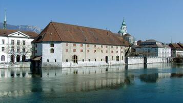 Un bâtiment historique doté d’une tour imposante et d’une vaste étendue d’eau au premier plan.