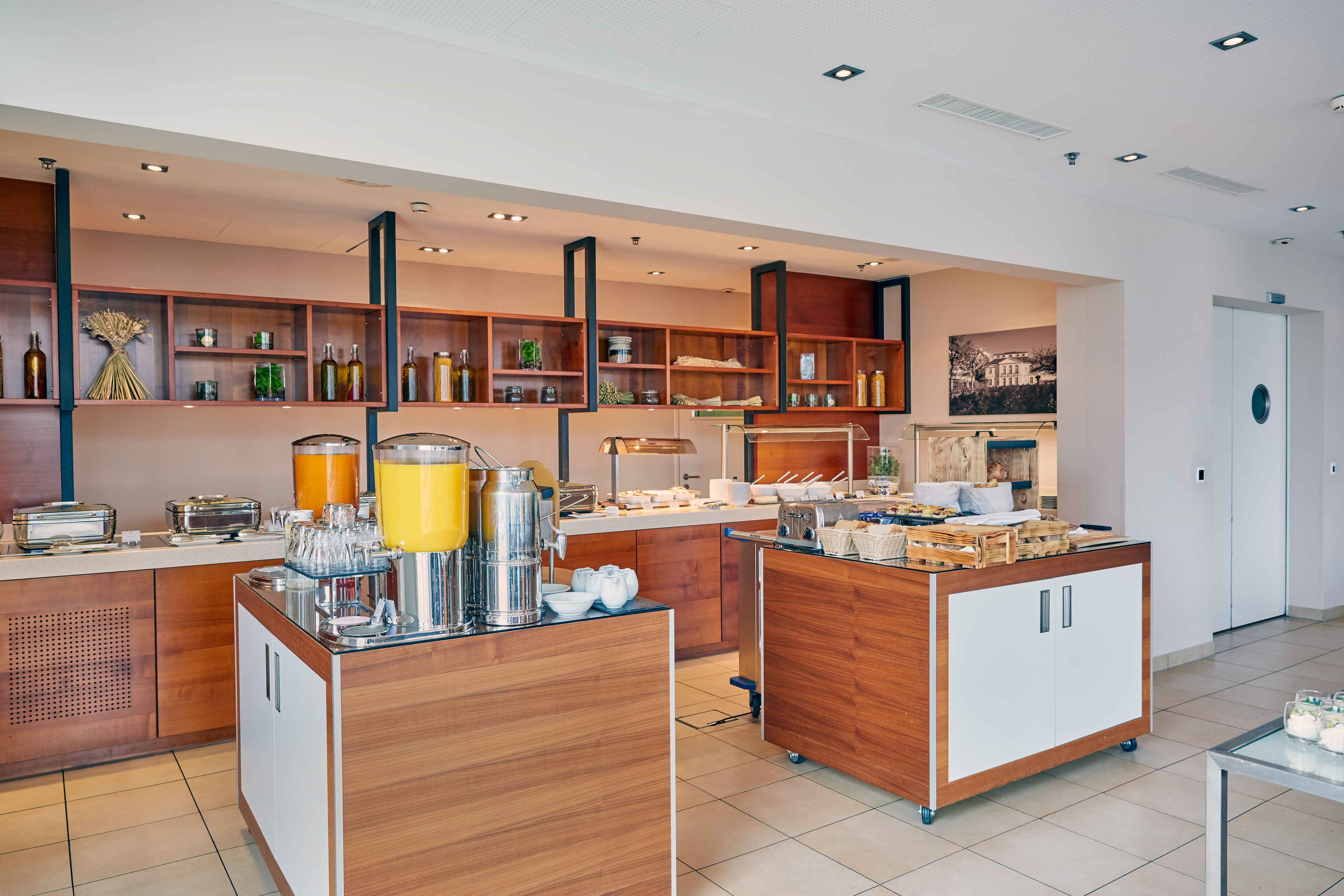 Una cocina moderna con armarios de madera, una barra desayunadora y diversos electrodomésticos.
