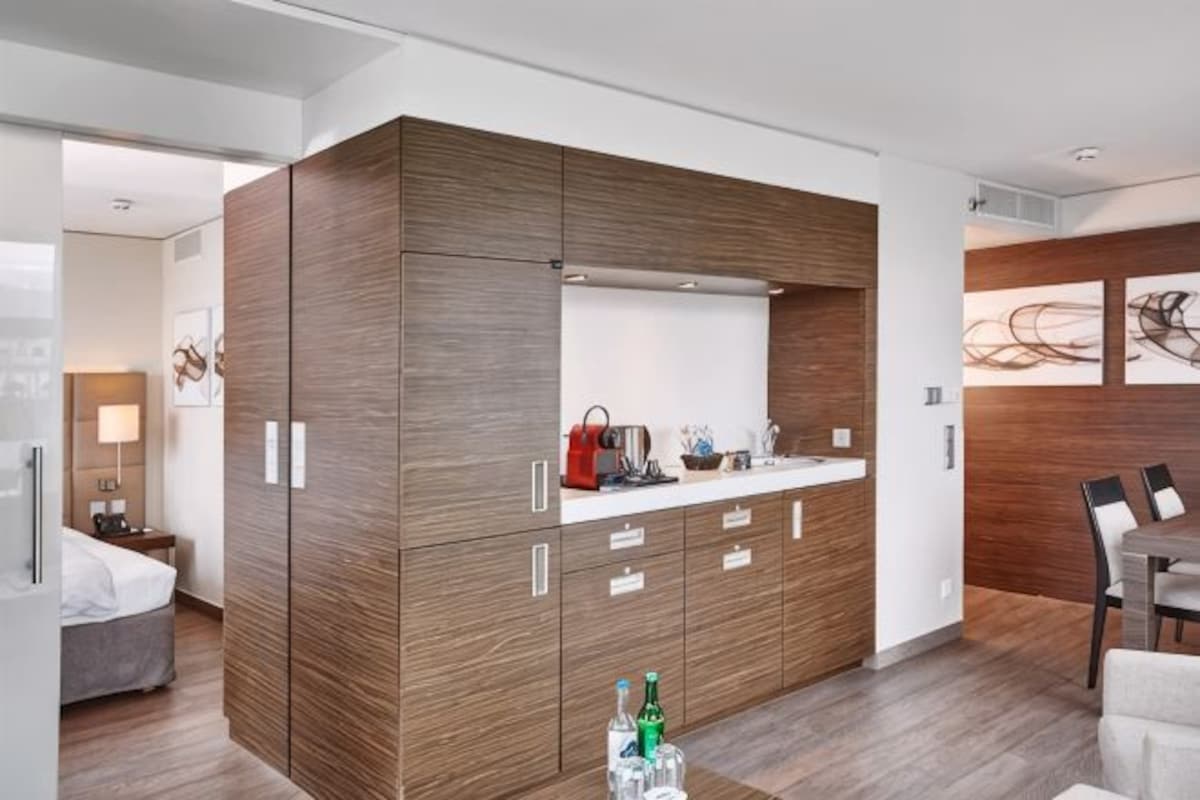 Una cocina moderna con armarios de madera, una encimera y un comedor con mesa y sillas.