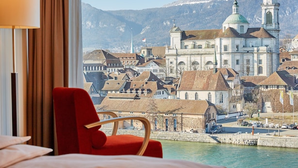 A hotel room with a view of a historic town and a river. - H4 Hotel Solothurn (Solothurn)
