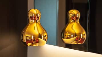 Two golden light fixtures with a modern design, reflecting their surroundings.
