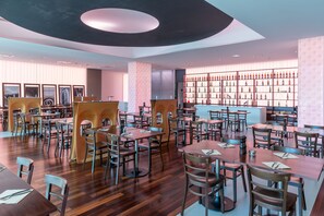 Enjoy a meal in the dining area with a variety of seating options and a central table.