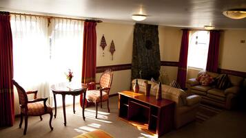 Una sala de estar con chimenea de piedra, un sofá, un sillón y una mesa de centro.