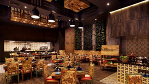 A restaurant with wooden flooring, patterned chairs, and pendant lighting. - Grand Chennai by GRT Hotels (Chennai)